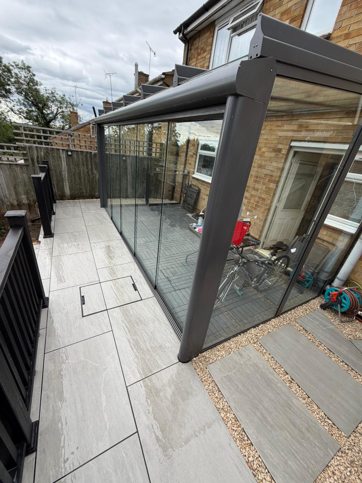 Porcelain paving around a glass veranda